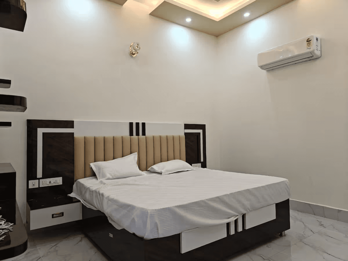 Girivar Dham air-conditioned deluxe guest room with clean king bedding in Vrindavan